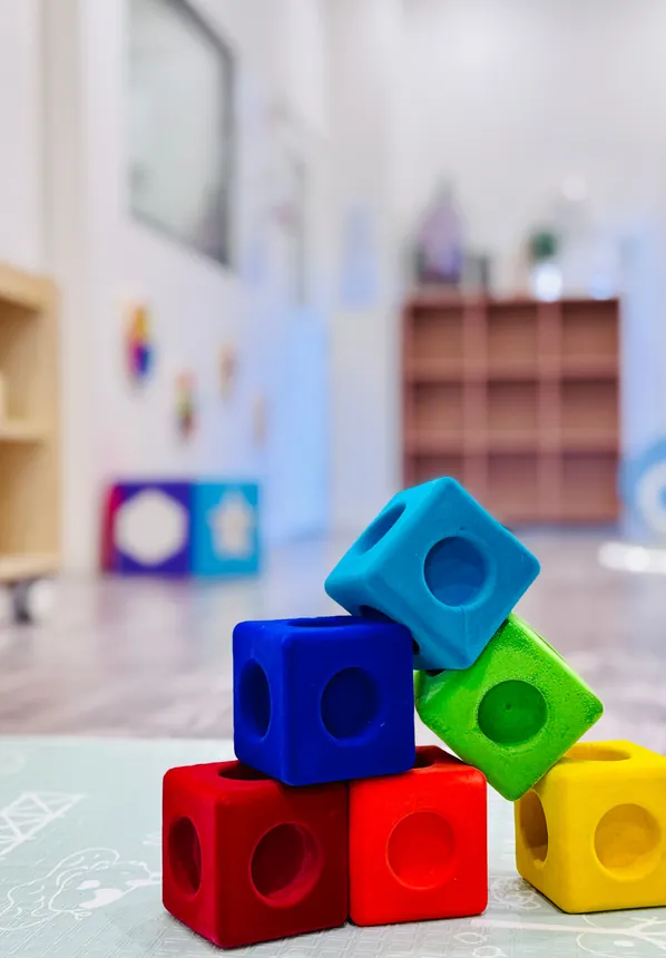Coloured stacking cubes on the floor of the Cuddle Cubs room